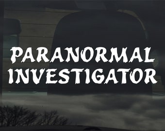 Könnte beinhalten: Weißer Vinyl-Aufkleber mit den Worten "PARANORMAL INVESTIGATOR" in einer stilisierten Schriftart auf schwarzem Hintergrund.