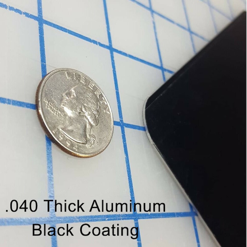 May include: A close-up of a black metal sheet with a .040 thick aluminum black coating. A US quarter is shown for scale.