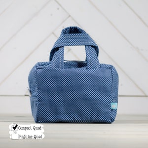 May include: A small blue and white polka dot tote bag with two handles. The bag is labeled "Compact Quad" and "Regular Quad".