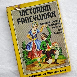 May include: A vintage book titled "Victorian Fancywork" with a yellow cover. The cover features a needlepoint illustration of two figures in period clothing, with the text "Nineteenth-Century Needlepoint Patterns and Designs".
