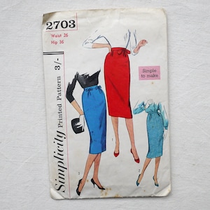 May include: Vintage Simplicity sewing pattern 2703, with illustrations of pencil skirts in red, blue, and checkered patterns. The pattern includes waist and hip measurements of 66 and 91 cm, respectively. The text "Simple to make" is also visible.