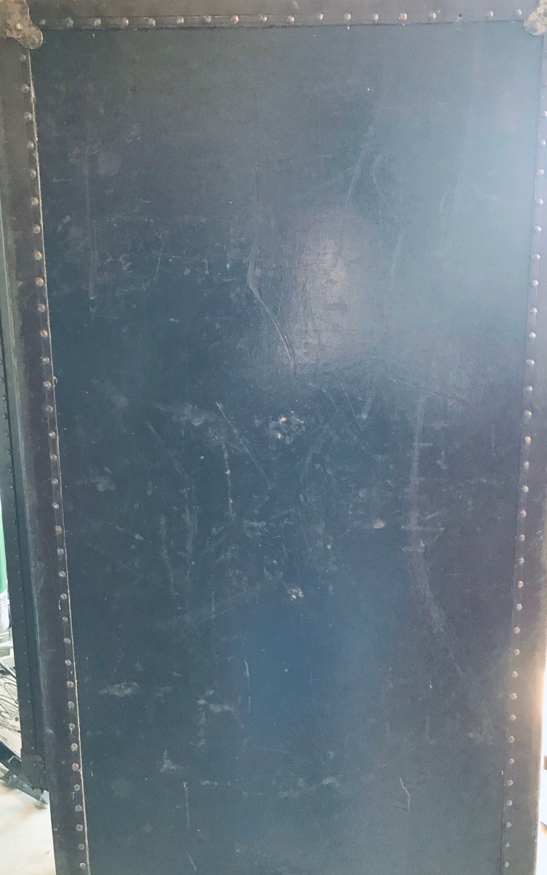 May include: A dark blue vintage suitcase with metal rivets around the edges.