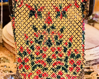 May include: A vintage gold mesh purse with a floral pattern in shades of red, green, and white. The purse has a chain strap and a fringe detail.