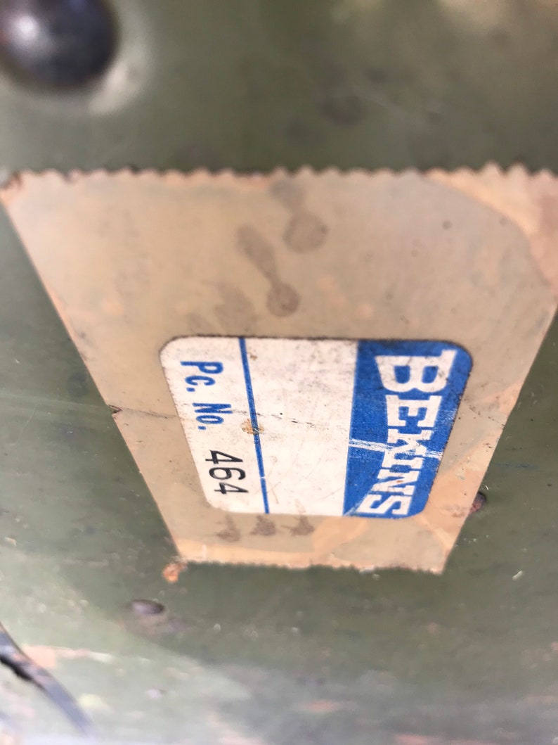 Puede incluir: Primer plano de una etiqueta blanca con texto azul que dice "Siemens" y "Pc. No. 464" sobre una superficie verde.
