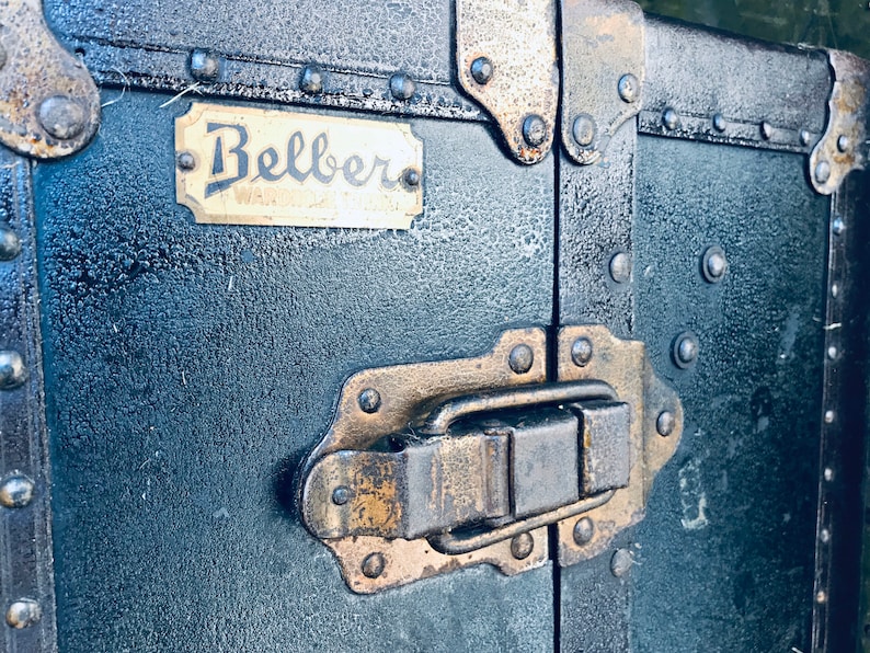May include: A vintage black suitcase with brass hardware and a brass nameplate that reads "Belber".