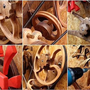 May include: A close-up of a wooden kinetic sculpture with intricate gears and pulleys. The sculpture is made of various shades of wood and features a red accent piece. The sculpture is being assembled with a power drill.