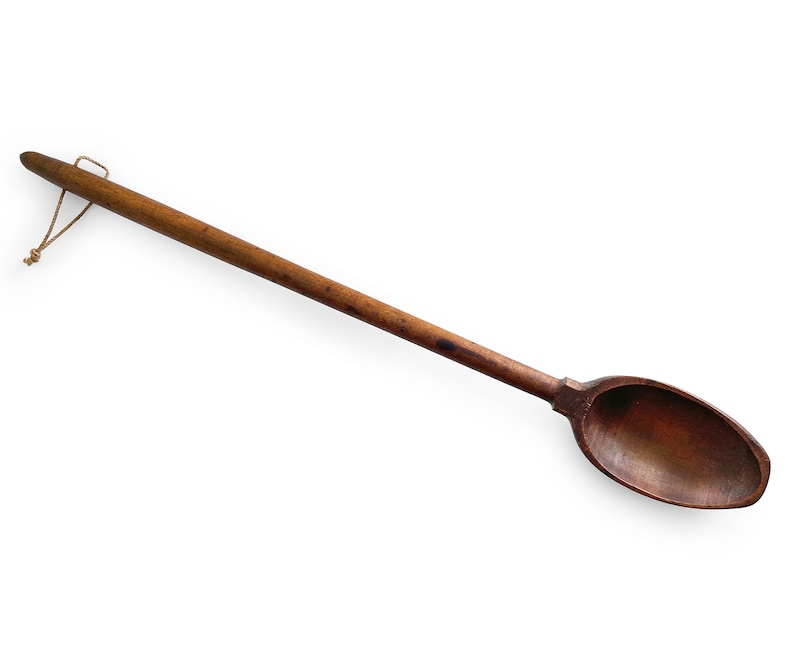 May include: A long, wooden spoon with a brown finish and a string attached to the handle.