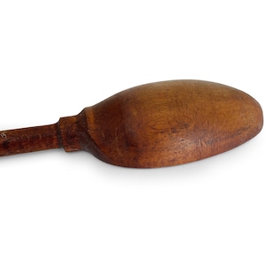 May include: A wooden spoon with a long handle and a rounded bowl. The spoon is made of dark brown wood and has a smooth, polished finish.