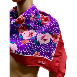May include: A purple silk scarf with a floral pattern and white polka dots. The scarf features large pink and red roses. The border is a solid red color. The brand name "BILLBLASS" is printed in white on the red border.