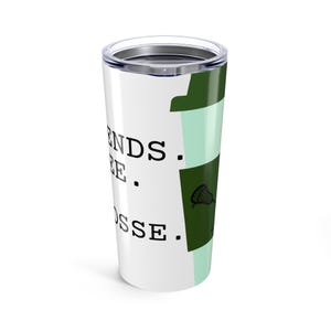 May include: A white tumbler with a silver lid features the words "Friends. Coffee. Lacrosse." in black. A green coffee cup design with a lacrosse stick graphic is on the side. The tumbler is designed to keep drinks hot or cold.