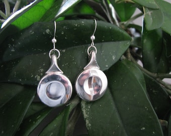 Peut inclure: Une paire de boucles d'oreilles en argent avec un design circulaire. Les boucles d'oreilles ont une finition lisse et polie et un style simple et élégant.