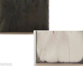 May include: Two fabric swatches, one black and one white. The black swatch is a solid color, while the white swatch has a subtle texture.