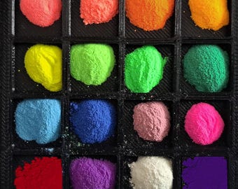 May include: A tray of 16 small containers, each filled with a different colored powder. The colors include red, orange, yellow, green, blue, purple, pink, and white.