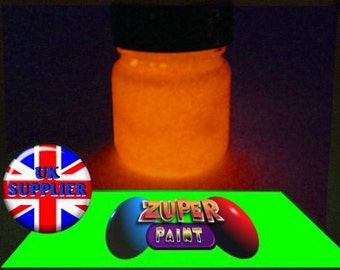 Könnte beinhalten: Ein kleines Glasgefäß gefüllt mit leuchtend orangefarbener Leuchtfarbe. Das Gefäß hat einen schwarzen Deckel und ist mit "ZUPER PAINT" beschriftet.