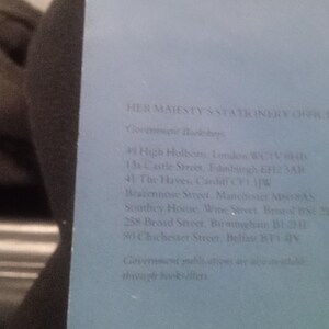 Puede incluir: Primer plano de una cubierta de libro azul con el texto "HER MAJESTY'S STATIONERY OFFICE" y varias l&iacute;neas de texto debajo, incluidas direcciones de librer&iacute;as gubernamentales en el Reino Unido.