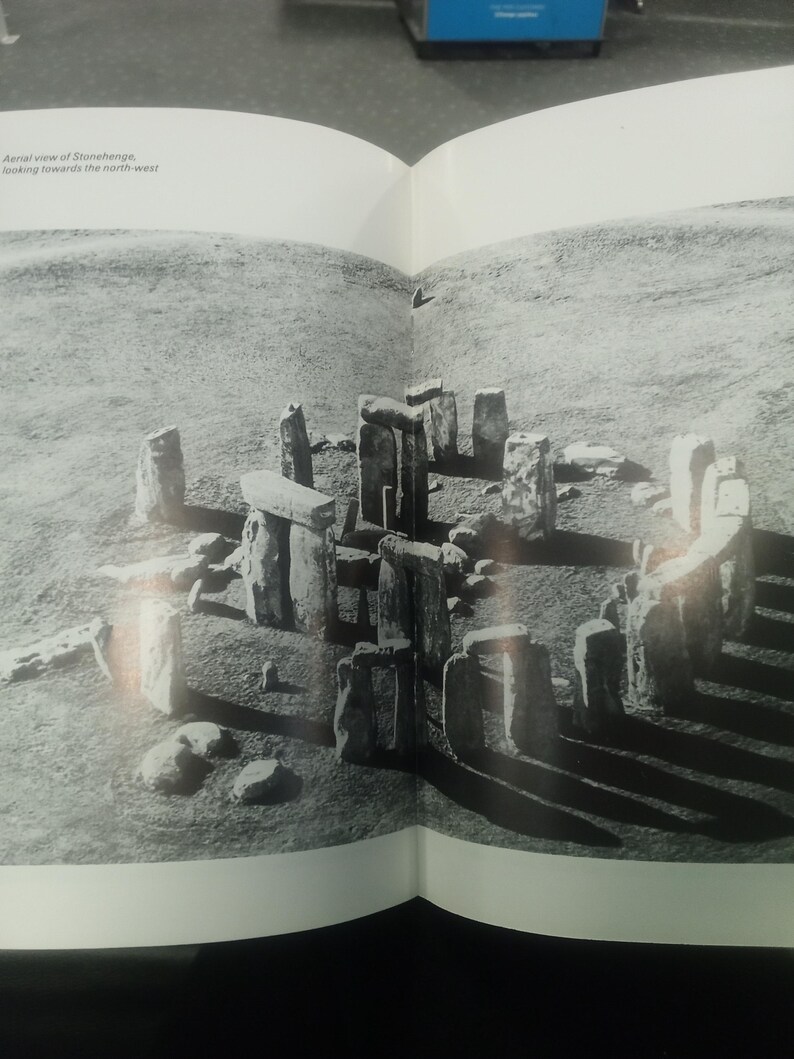 Puede incluir: Vista a&eacute;rea en blanco y negro de Stonehenge, un monumento prehist&oacute;rico en Inglaterra. La imagen muestra el c&iacute;rculo de piedra y el paisaje circundante. El texto dice: Vista a&eacute;rea de Stonehenge, mirando hacia el noroeste.