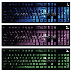 May include: Three keyboard overlays with a galaxy design. The first overlay is blue, the second is purple, and the third is green. Each overlay has the standard keyboard layout with letters, numbers, and symbols. The overlays are labeled 1, 2, and 3.