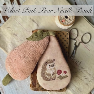 May include: A pink velvet pear-shaped needle book with a green leaf and a cross-stitch design of a hedgehog with red mushrooms. The text "Velvet Pink Pear Needle Book" is at the top of the image and the text "Stacy Nash Designs" is at the bottom of the image.