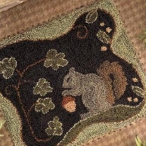 Peut inclure: Tapis carré fait à la main représentant un écureuil tenant un gland. Le tapis a un fond marron foncé avec des accents verts et bruns, dont des feuilles et une bordure. L'écureuil est représenté dans des tons de gris et de marron.