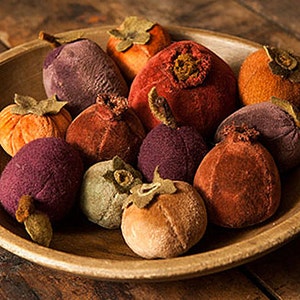 May include: A wooden bowl filled with velvet fruit. The fruit is in shades of orange, red, purple, and brown.