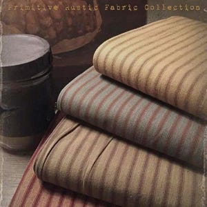 May include: Four rolls of striped fabric in various shades of brown, red, and beige. The fabric is labelled "Prairie Wovens Primitive Rustic Fabric Collection" and "available at: Cottage Threads".