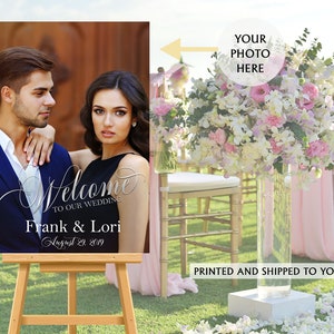 May include: A rectangular wedding welcome sign on a wooden easel featuring a photograph of a couple. The text reads Welcome to our wedding, Frank & Lori, and August 29, 2019. A circular graphic with an arrow points to the photo area with the text Your photo here.