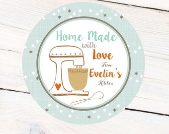 May include: A round, light blue sticker with white stars and brown stars. The sticker has a white circle in the center with the text "Home Made with Love from Evelin's Kitchen". There is a brown and orange illustration of a stand mixer with a brown heart on the side.