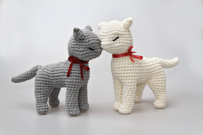 No-sew standing cat crochet pattern – handmade gray cat toy with a red ribbon around its neck, standing on four legs. Digital PDF amigurumi pattern for DIY cat