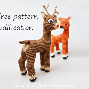 May include: Two crocheted deer, one brown and one orange, standing side-by-side. The brown deer has a red nose and large eyes. The text "+ free pattern modification" is visible at the top of the image.