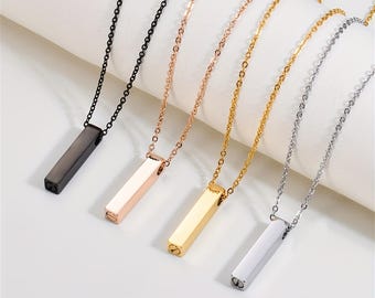May include: A collection of five necklaces with rectangular pendants. The necklaces are in various metallic finishes: black, rose gold, gold, and silver. Each pendant hangs from a delicate chain, creating a minimalist and modern aesthetic.