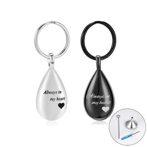 Può includere: Due portachiavi a forma di goccia, uno bianco e uno nero, ciascuno con un portachiavi argentato. Il portachiavi bianco ha il testo "Always in my heart" e un simbolo a cuore. Il portachiavi nero ha lo stesso testo e simbolo. Sono inclusi un piccolo imbuto e degli attrezzi.