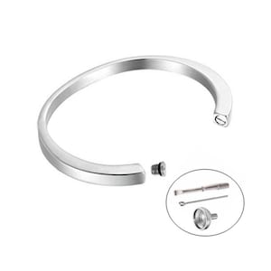 May include: A silver cremation bracelet with a screw-on opening for ashes. The bracelet comes with a small funnel and a screwdriver for filling.