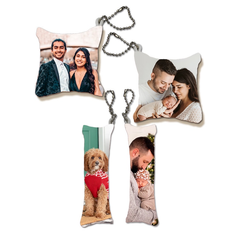 May include: Set of four personalized photo keychains. Two are square shaped and two are rectangular. One keychain features a couple with a baby, another features a couple, another features a dog, and the last features a man holding a baby.