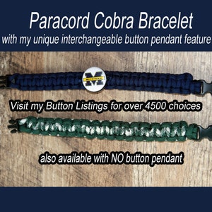 May include: Two paracord cobra bracelets, one blue and one green with white accents. The blue bracelet has a button pendant with the University of Michigan logo. The text "Visit my Button Listings for over 4500 choices" and "also available with NO button pendant" is visible.
