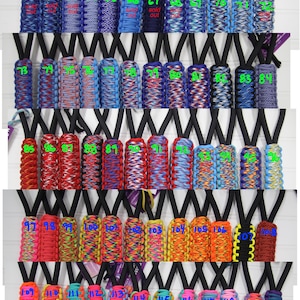 May include: A collection of 120 colorful paracord keychains with numbers 61 to 120. The keychains are made with different color combinations of paracord.