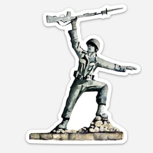 May include: A watercolor painting of a soldier holding a rifle in the air, standing on a rocky base. The soldier is wearing a helmet and a military uniform. The painting is done in shades of gray and blue.