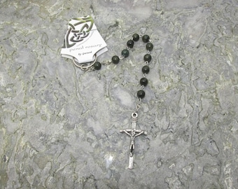 Puede incluir: Un pequeño llavero de plata con un nudo celta y un rosario de piedra verde adjunto. La etiqueta dice "Penal Rosary by Gerard".