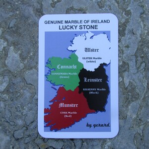 May include: A rectangular card titled GENUINE MARBLE OF IRELAND LUCKY STONE featuring a map of Ireland divided into four colored regions: white Ulster, green Connacht, black Leinster, and red Munster, with text identifying the marble types.