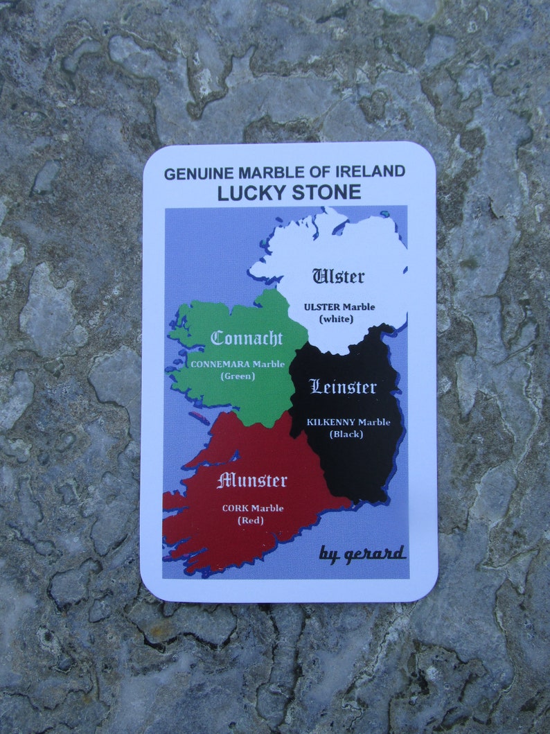 May include: A rectangular card titled GENUINE MARBLE OF IRELAND LUCKY STONE featuring a map of Ireland divided into four colored regions: white Ulster, green Connacht, black Leinster, and red Munster, with text identifying the marble types.