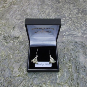 May include: A pair of sterling silver Celtic knot earrings in a black box with a white label that reads "Sterling Silver". The box is labeled "Connemara Marble by Gerard Made in Ireland".