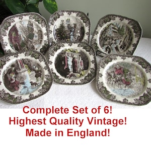 May include: A set of six vintage plates with detailed, sepia-toned scenes. Each plate features a different winter landscape with figures, framed by a dark brown leaf pattern. The plates are octagonal in shape.