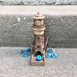 May include: A wooden lighthouse-shaped dice tower with a blue dice inside and five blue dice scattered around the base.
