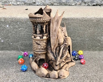 Può includere: Una scultura di drago in ceramica marrone con una torre sulla schiena. Il drago è rannicchiato con le ali spiegate. Ci sono diversi dadi colorati sparsi intorno alla scultura.