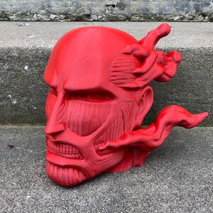 May include: A red 3D printed bust of a character with a detailed muscular face and a flowing red mane. The bust is a popular anime character.