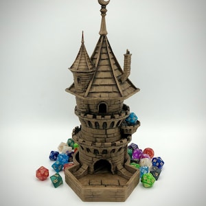May include: A brown, stone-like tower with a crescent moon on top, designed to hold dice. The tower has a base with a hexagonal opening for rolling dice. There are several colorful dice scattered around the tower.