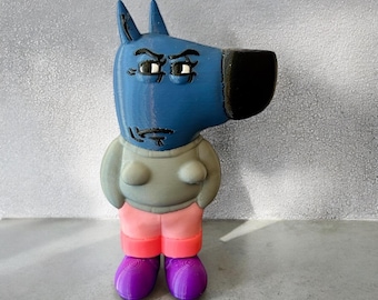 Peut inclure: Une figurine en 3D imprimée en bleu et gris d'un chien de dessin animé portant un pull gris et un pantalon rose. Le chien a un nez noir et des chaussures violettes.