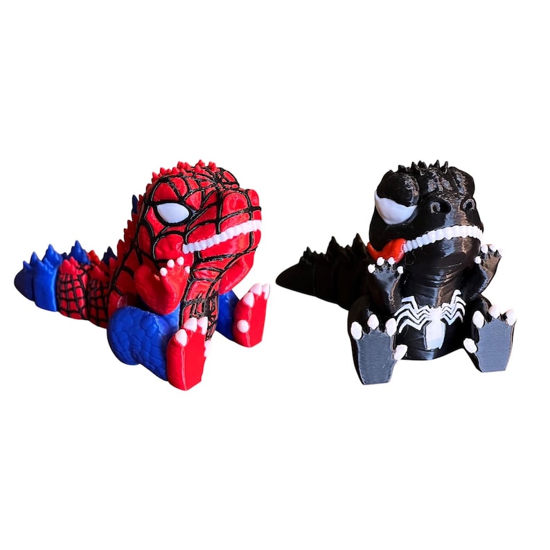 May include: Two 3D-printed figurines of cartoon dinosaurs. One is red, blue, and white, resembling Spider-Man. The other is black and white, with a red tongue, resembling Venom. Both are in a sitting position.
