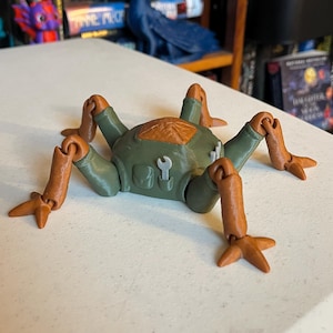 May include: A 3D-printed toy insect with a green body, brown legs, and a brown top. The toy has a wrench and a screwdriver design on the front. The legs are articulated, allowing for different poses. This unique toy is a creative and fun item.