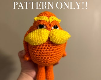 Puede incluir: Juguete de peluche tejido a crochet del personaje del libro "El Lorax" de Dr. Seuss. El juguete es naranja con bigote y cejas amarillas. El juguete está siendo sostenido por una mano. El texto "DIGITAL PATTERN ONLY!!" está escrito sobre el juguete.