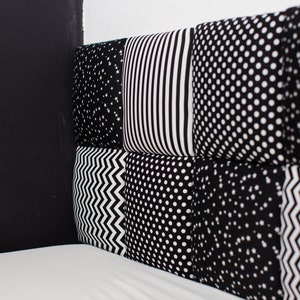 Puede incluir: Cuadrados de tela con patrones en blanco y negro cosidos juntos para crear una cabecera de cama. La cabecera est&aacute; hecha de diferentes patrones, incluyendo estrellas, rayas, lunares y zigzags.